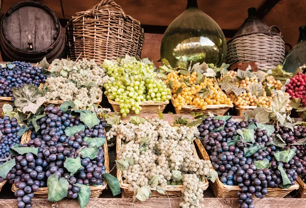 Different varieties of grapes in the wicker baskets — Stock Photo, Image