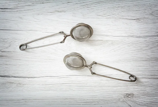 Two tea strainers on the wooden background, kitchen equipment — Stock Photo, Image