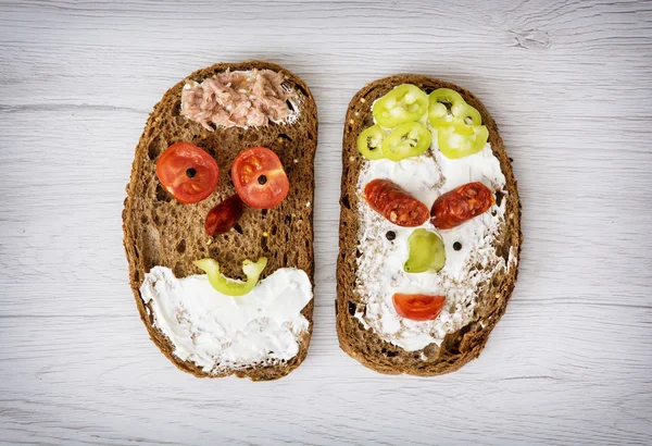 Two funny faces made of tasty bread, humorous creative food — Stock Photo, Image