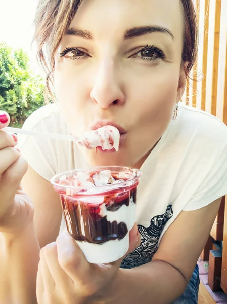 Junge kaukasische Frau isst cremiges Eis mit Erdbeere — Stockfoto
