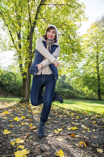 Unga positiva kvinna poserar i höstens natur — Stockfoto