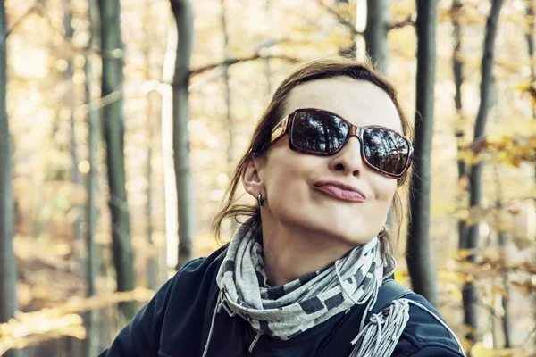 Mladá žena Kavkazský v podzimním lese dělá šílené tvář — Stock fotografie