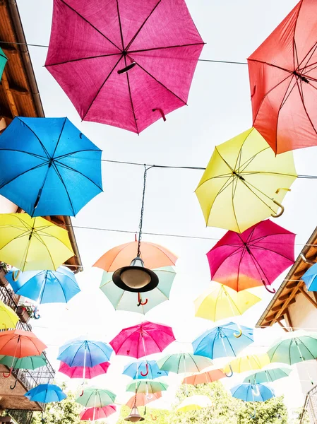 Brilhante colorido pendurado guarda-chuvas cena — Fotografia de Stock