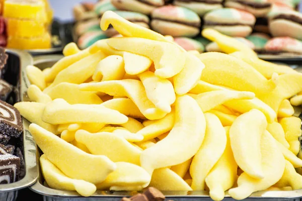 Plastik kap içinde sarı lezzetli meyan şekerler — Stok fotoğraf