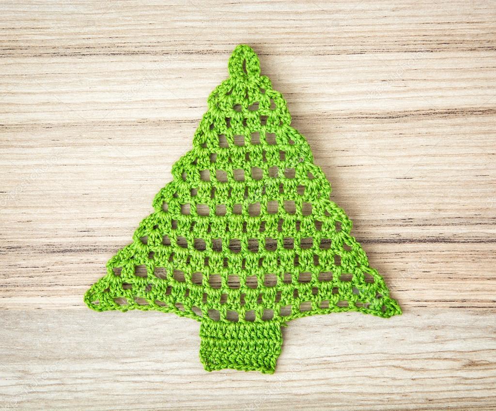 Green crochet christmas tree on the wooden background