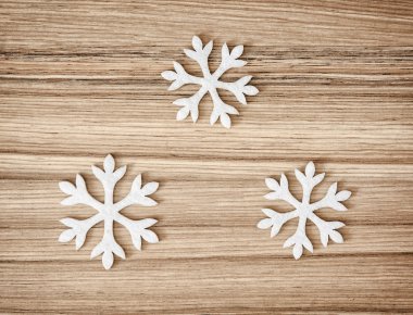 Ahşap zemin üzerinde üç beyaz kar taneleri