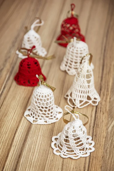 Group of beautiful crochet christmas bells on the wooden texture — Stock Photo, Image