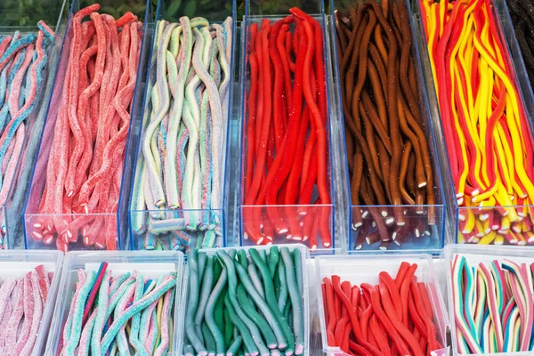 Multicolor tasty licorice candies in plastic containers — Stock Photo, Image