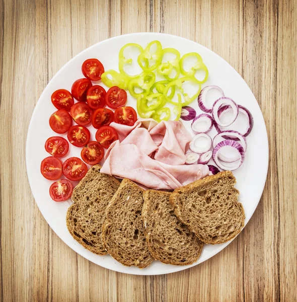 Whole wheat bread with ham, onion, paprika and cherry tomatoes — Stock Photo, Image