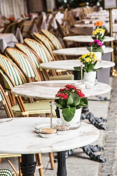 Cadeiras de vime e mesas de pedra com flores em vaso — Fotografia de Stock