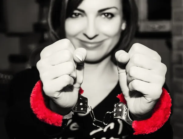 Young caucasian woman posing with red handcuffs at the party — Stock Photo, Image