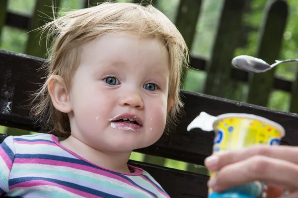 Little girl eats yogurt — Stock Photo, Image