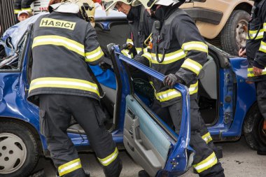 İtfaiyeciler bir araba enkazından kesme kapılar kaldırma