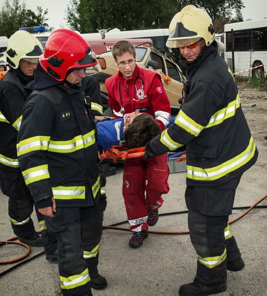 Feuerwehrleute und Retter transportieren Verletzte auf einer Trage ab — Stockfoto