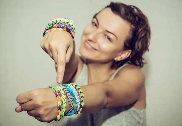 Young beautiful brunette with colorful rubber bracelets on her h — Stock Photo, Image