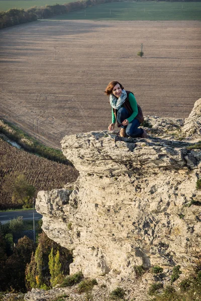 Młoda kobieta pozowanie na wysokiej skale — Zdjęcie stockowe