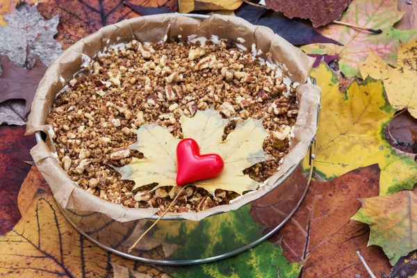 Cremiger Karamellkuchen mit Pekannüssen, Walnüssen und rotem Herz — Stockfoto