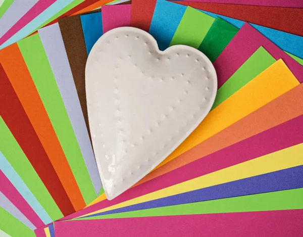 Λευκό μέταλλο καρδιά σε ένα πολύχρωμο χαρτιά — Φωτογραφία Αρχείου