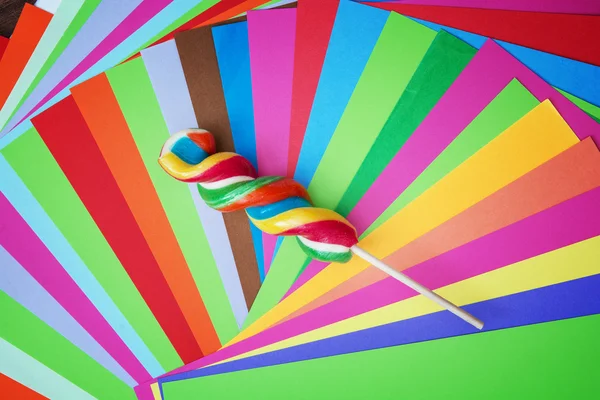 Colorful twisted sweet lollipop with brightly colored papers — Stock Photo, Image