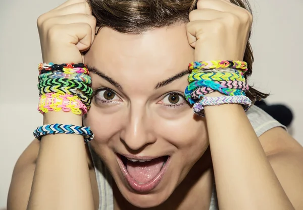 Jovem louca com pulseiras de borracha coloridas em suas mãos — Fotografia de Stock