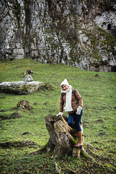 Nuori nainen turisti poseeraa puun tynkä — kuvapankkivalokuva