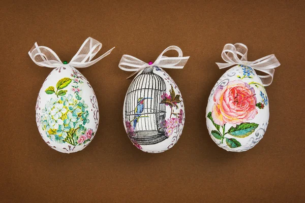 Üç Paskalya yumurtası kahverengi kağıt üzerinde dekore edilmiş — Stok fotoğraf