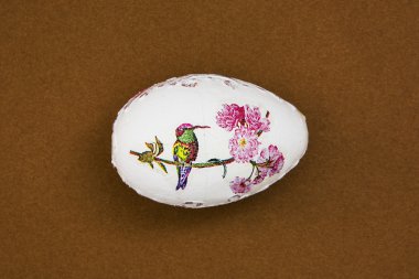 Güzel Paskalya yumurtası kahverengi zemin üzerinde kuş ile boyalı