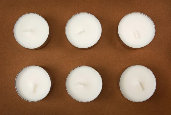 Sechs Kerzen auf dem braunen Hintergrund — Stockfoto