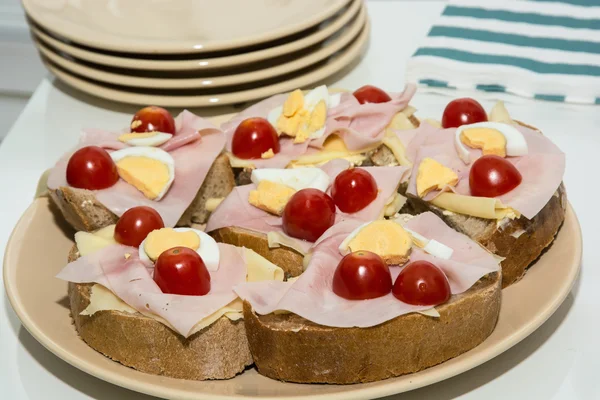 Sandwiches with egg, cheese, ham and cherry tomatoes — Stock Photo, Image