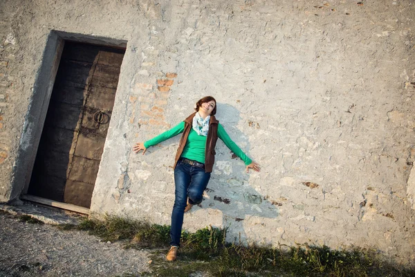 Genç kadın eski duvarın önünde poz — Stok fotoğraf