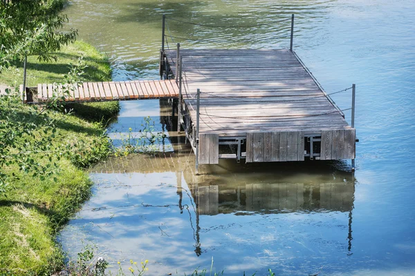 Muelle de madera se refleja en el agua tranquila —  Fotos de Stock