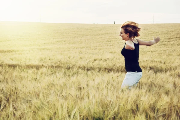 Crazy woman is jumping in the wheat field — Stock Photo, Image