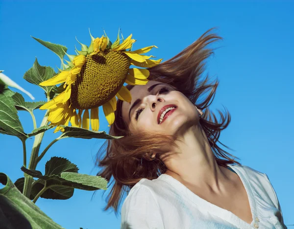 Joven mujer lanza su pelo por el girasol en el campo — Foto de Stock