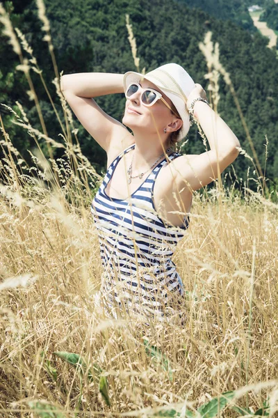 Молодая женщина в матросском костюме улыбается солнцу с руками за спиной — стоковое фото
