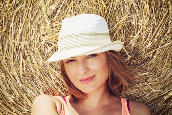 Young caucasian woman posing with haystack — Stock Photo, Image