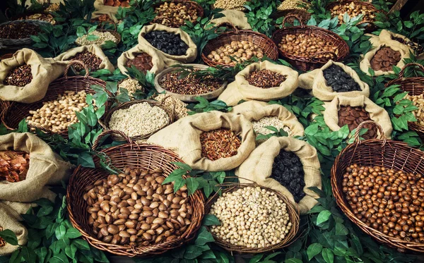 Imagen de varios tipos de nueces en cuencos de mimbre y arpillera — Foto de Stock