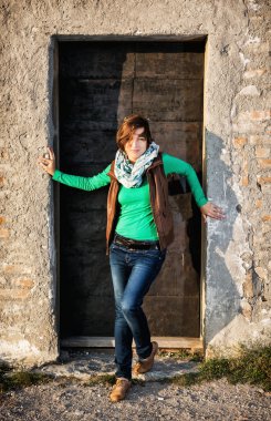 Beyaz kadın eski kapının önünde poz