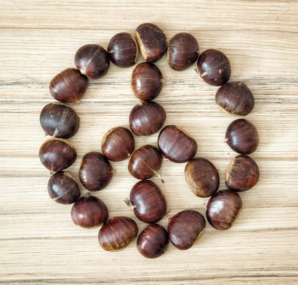 Chestnut peace symbol on the wooden plate — Stock Photo, Image