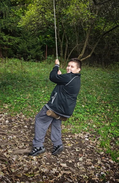 Young boy swing on the rope — Stock Photo, Image