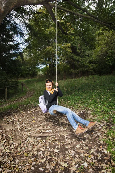 Glückliche junge Frau schwingt auf dem Seil — Stockfoto