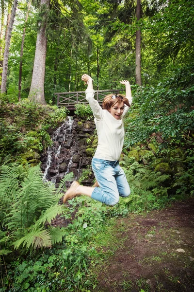 Junge Brünette springt im Park — Stockfoto