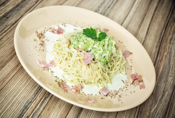 Tasty italian spaghetti with broccoli sauce, ham and garlic — Stock Photo, Image