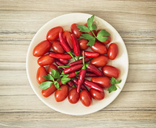 Pimentas saborosas e tomates cereja no prato — Fotografia de Stock