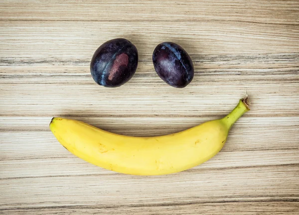 Смилейшее лицо банана и сливы, эмоции, фруктовая тема — стоковое фото