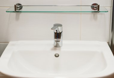 Yeni beyaz lavabo ve krom musluk kolu