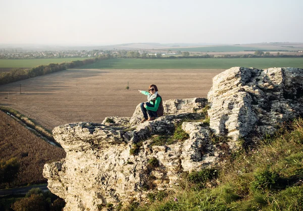 Młody kaukaski kobieta na skraju rock, wiejski krajobraz — Zdjęcie stockowe