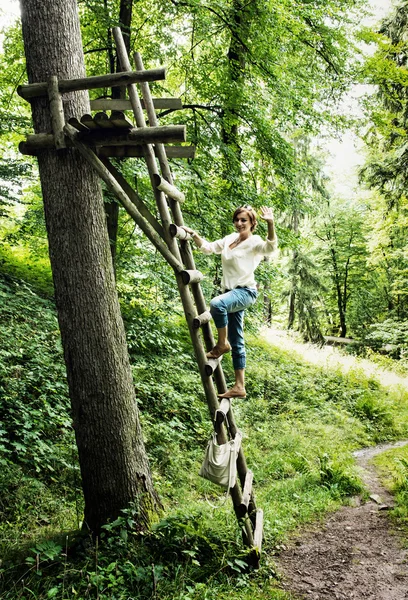 Młoda kobieta kaukaski, pozowanie na drabinie drewniane, naturalna scena — Zdjęcie stockowe