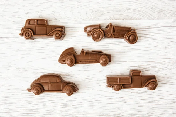 Set of chocolate car figures on wooden background — Stock Photo, Image