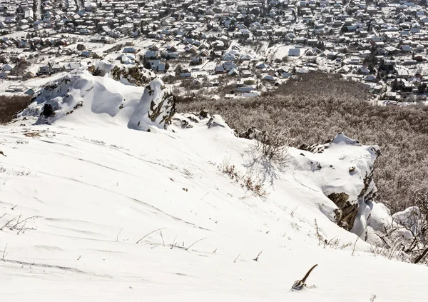 Schneebedeckte Felsen, Winterlandschaft und Dorf — Stockfoto