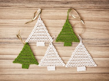 Ahşap arka plan üzerinde beş kroşe Noel ağaçları